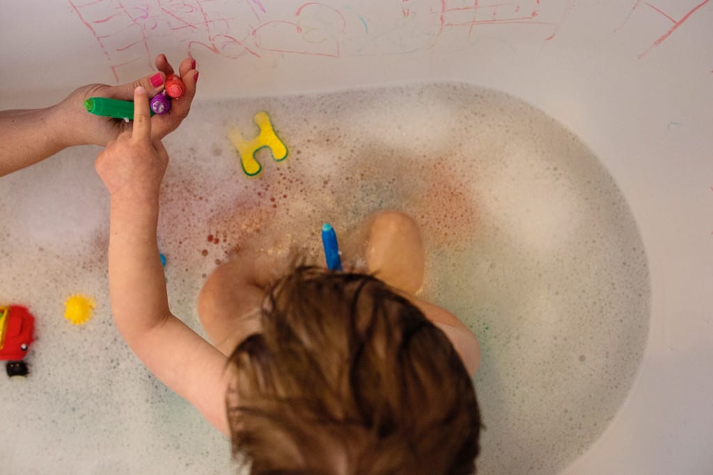 boy playing with bath crayons
