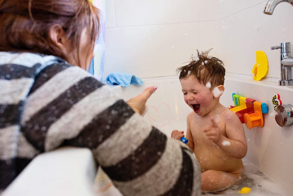 mom blowing bubbles at son during South Wales family photo session
