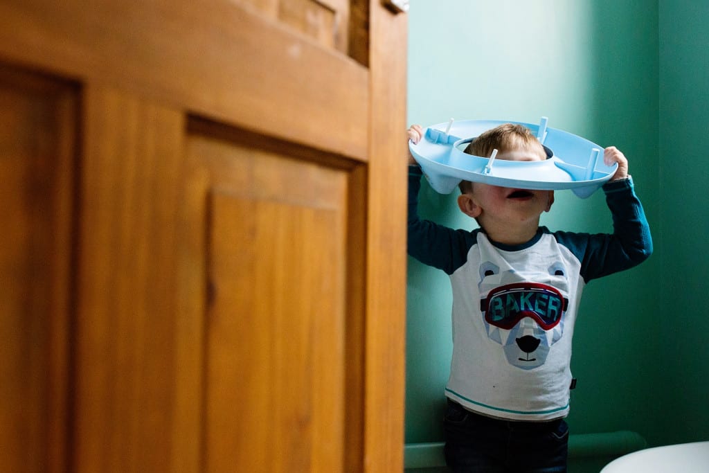 boy playing with toilet seat during session with South Wales family photographer