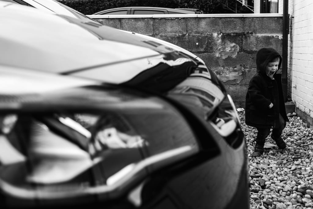 boy running around car during South Wales family session