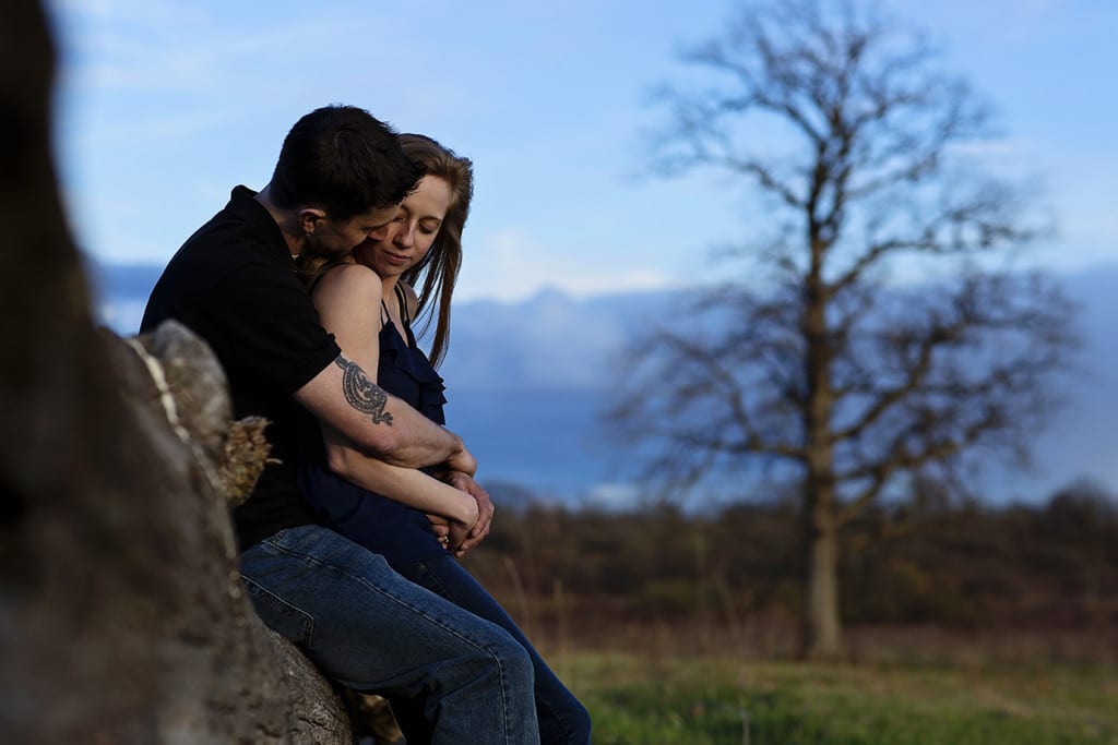 keeping warm on a log during Cornwall engagement session