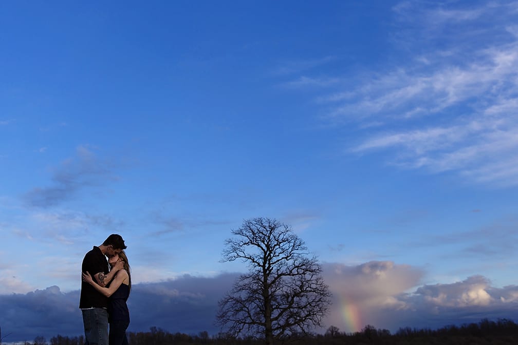 kiss and rainbow during Cornwall engagement session