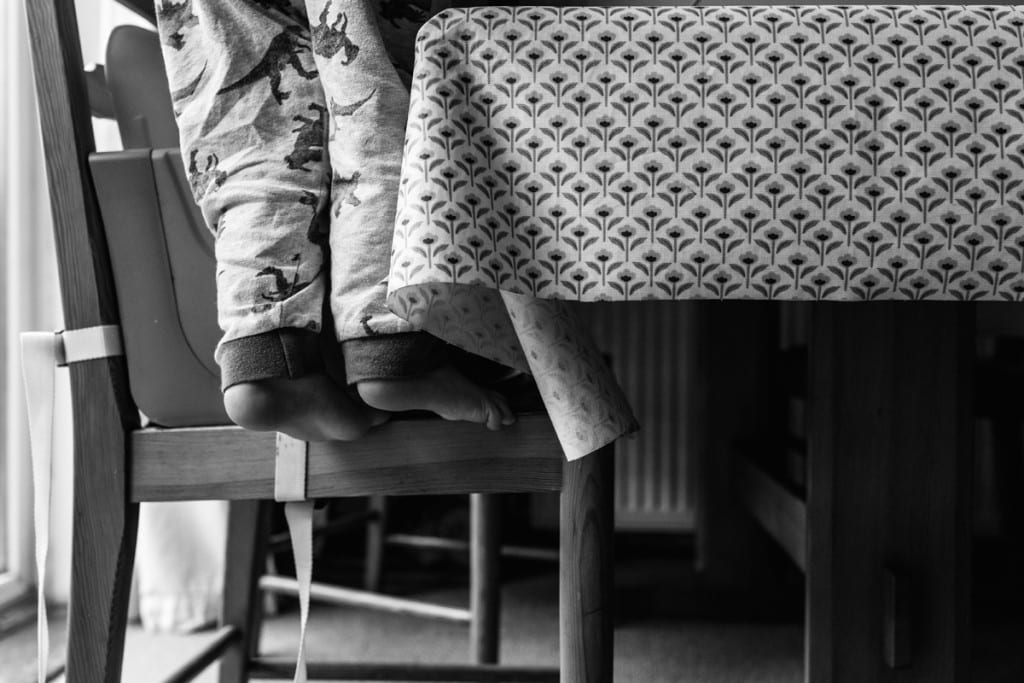 boy climbing down from chair during London family photography session