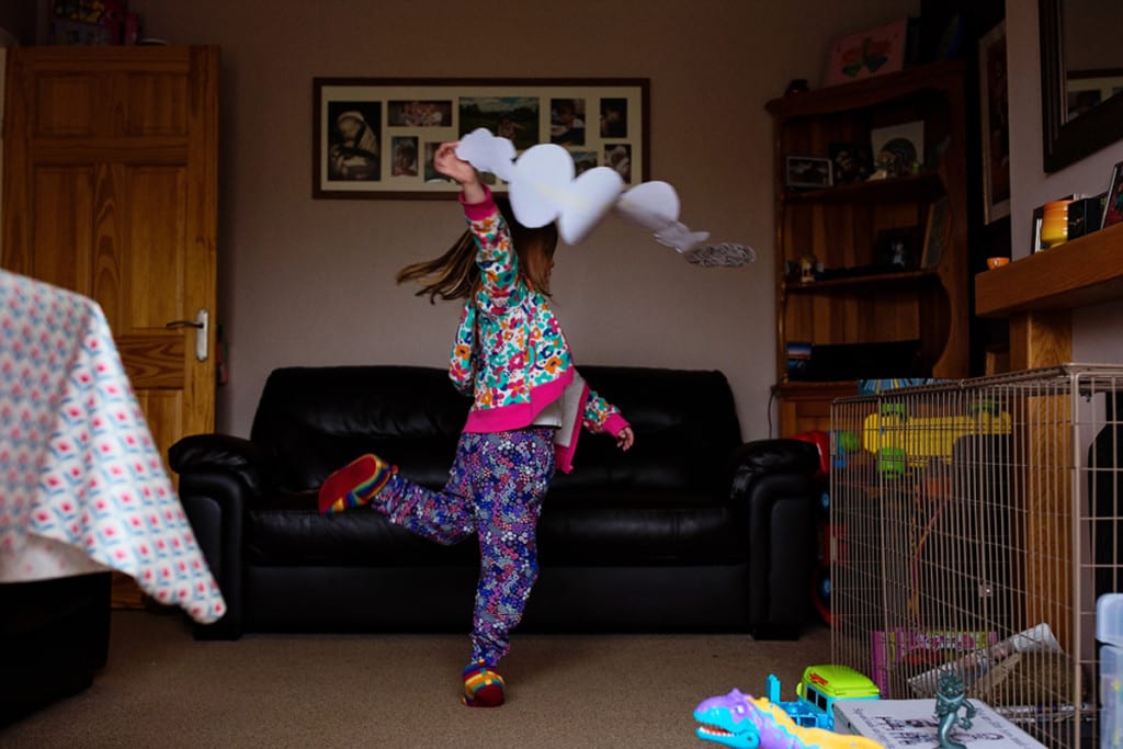 girl dancing with art project during London family photography session