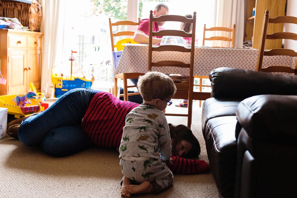 mom on floor digging under couch
