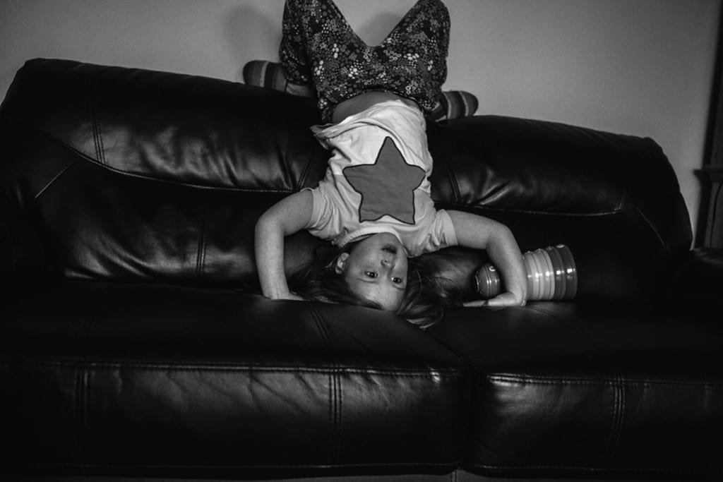 girl standing on head on the couch