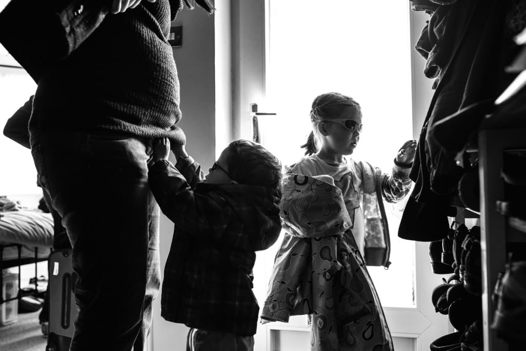 children and mother getting ready to leave house during London family photography session