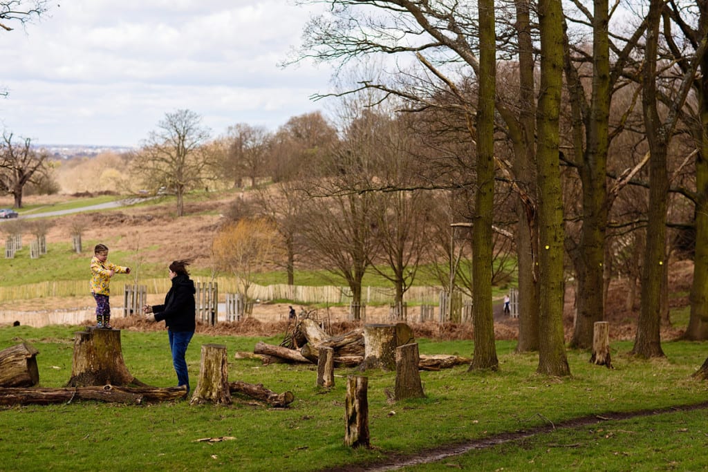 Mom catching leaping daughter in Richmond Park during London family photography session