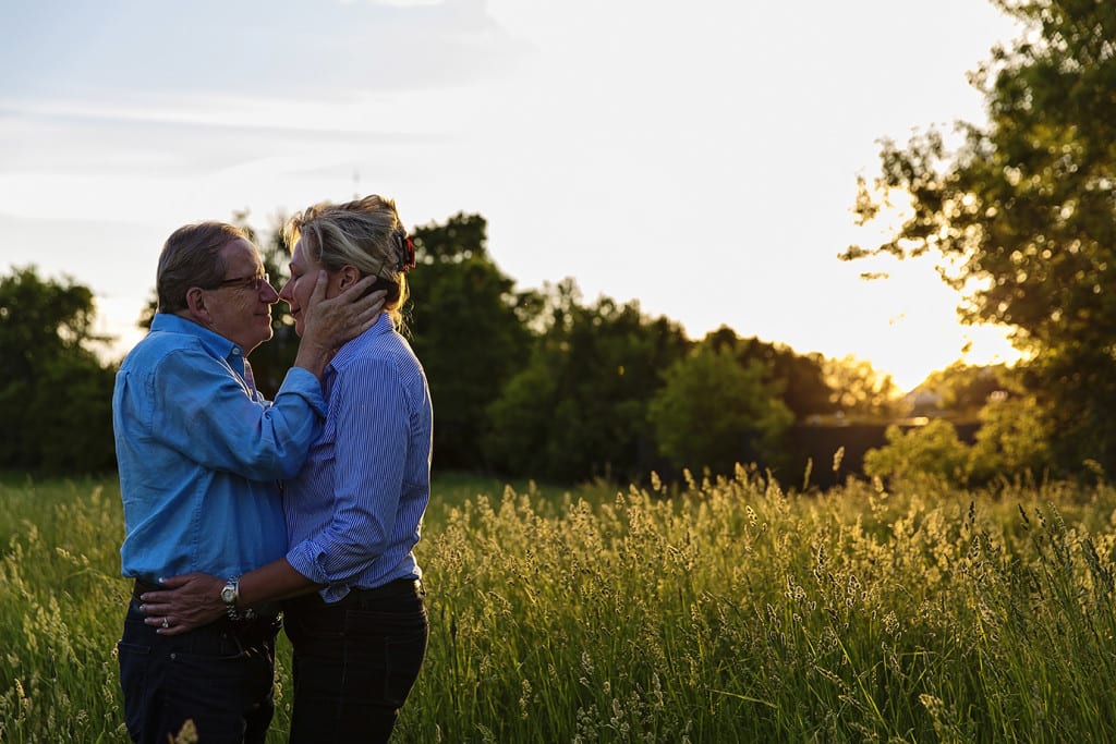 Man holding fiancee's face in field