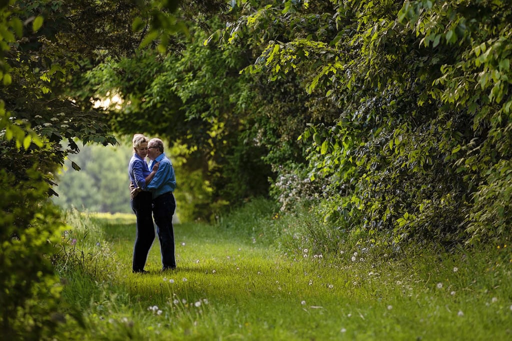 Couple hugging in tree tunnel