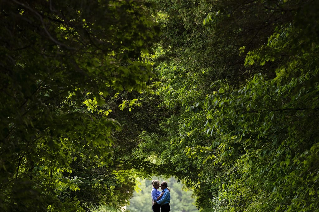 Couple standing together in tree tunnel