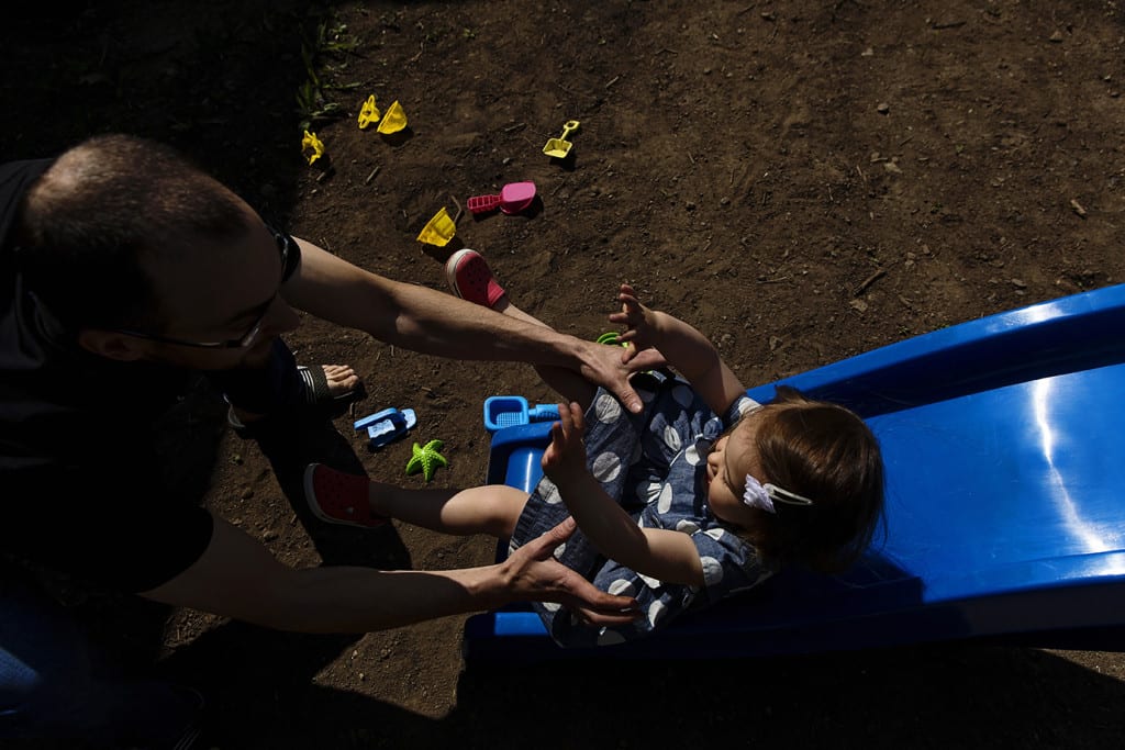 dad catching daughter on slide during family portrait session