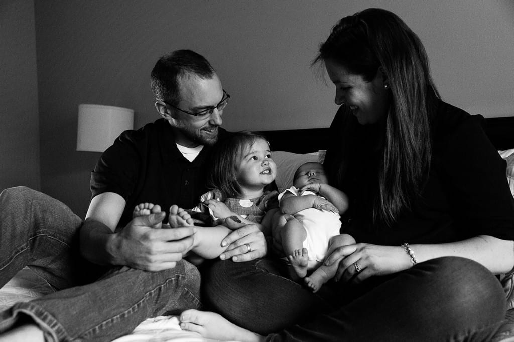 daughter looking at mom on bed during family portrait session