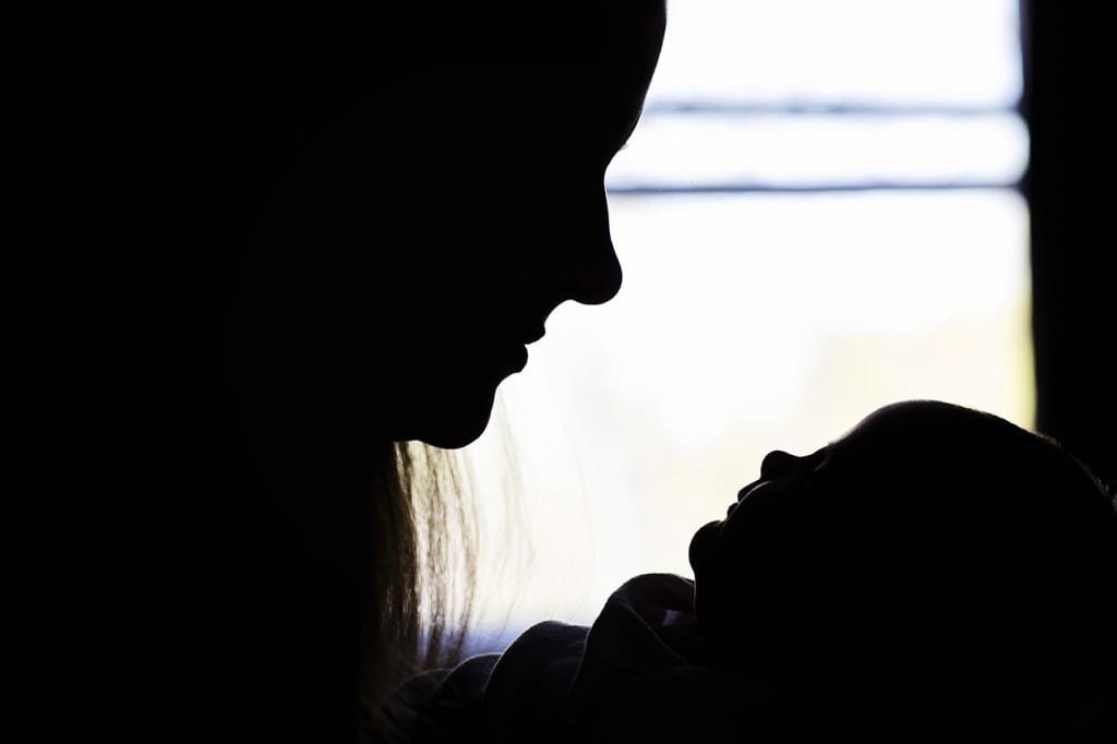 silhouette of mom looking at baby during family portrait session