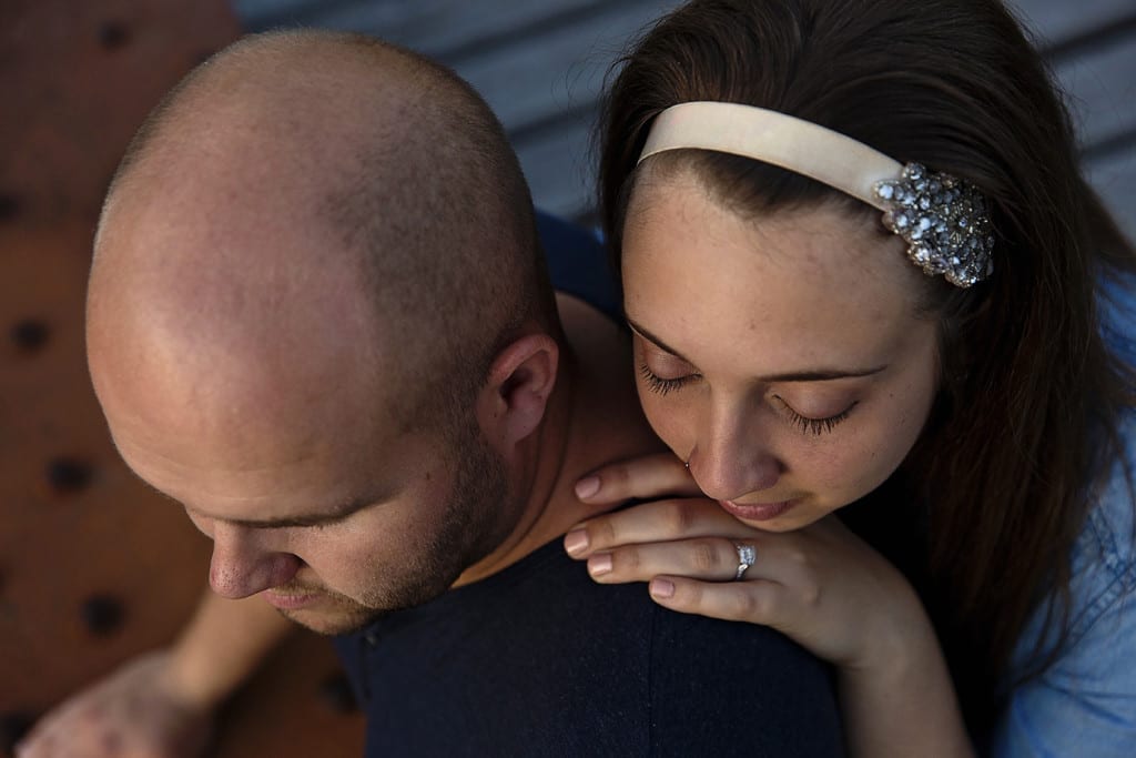 Woman rests head on fiance's shoulder during St Raphael's engagement session