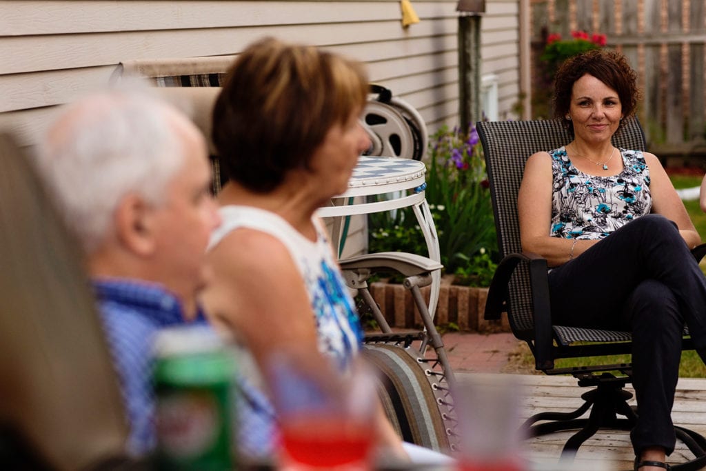 daughter smiling at parents on summer patio