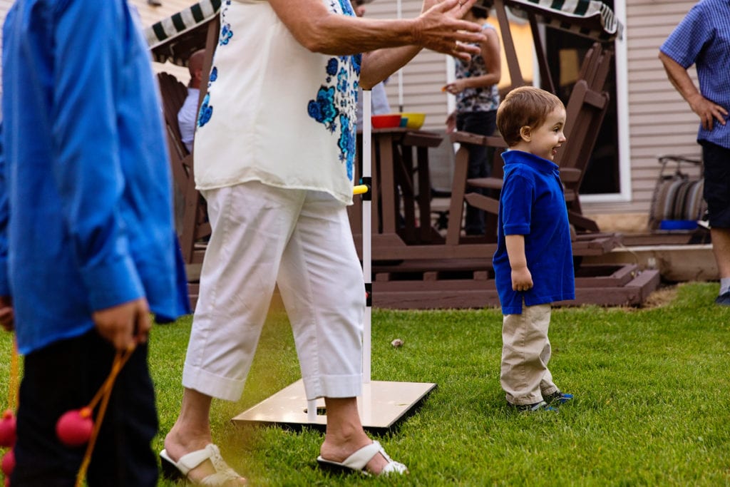 little boy in blue shirt outside with family during candid cornwall family photography session