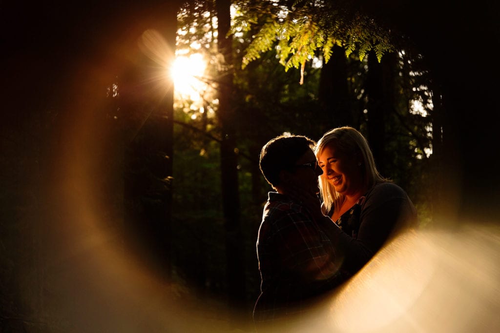 Girl holding fiance's face in woods