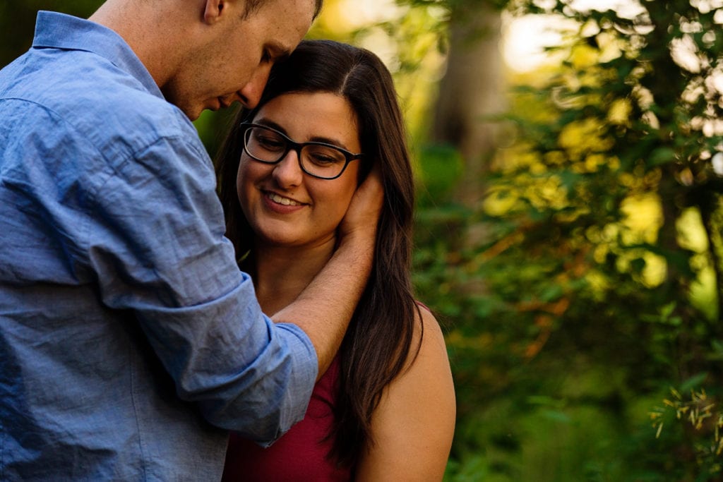Man with hands in girl's hair Ontario sunset engagement
