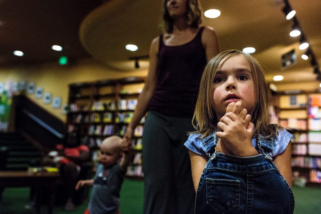 Little girl with hands peeking out of overalls