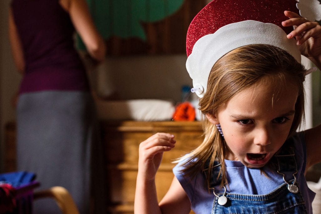 Little girl growling while wearing santa hat