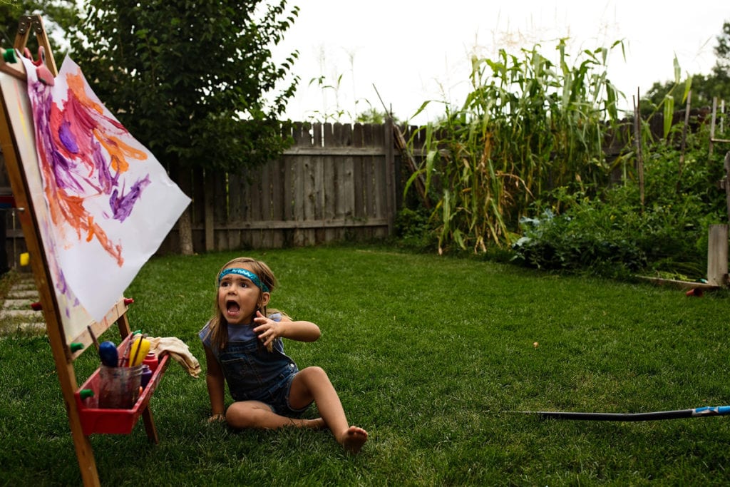 Little girl in headband on grass in backyard