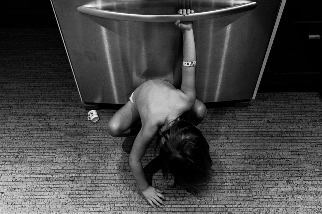 Girl hanging on fridge