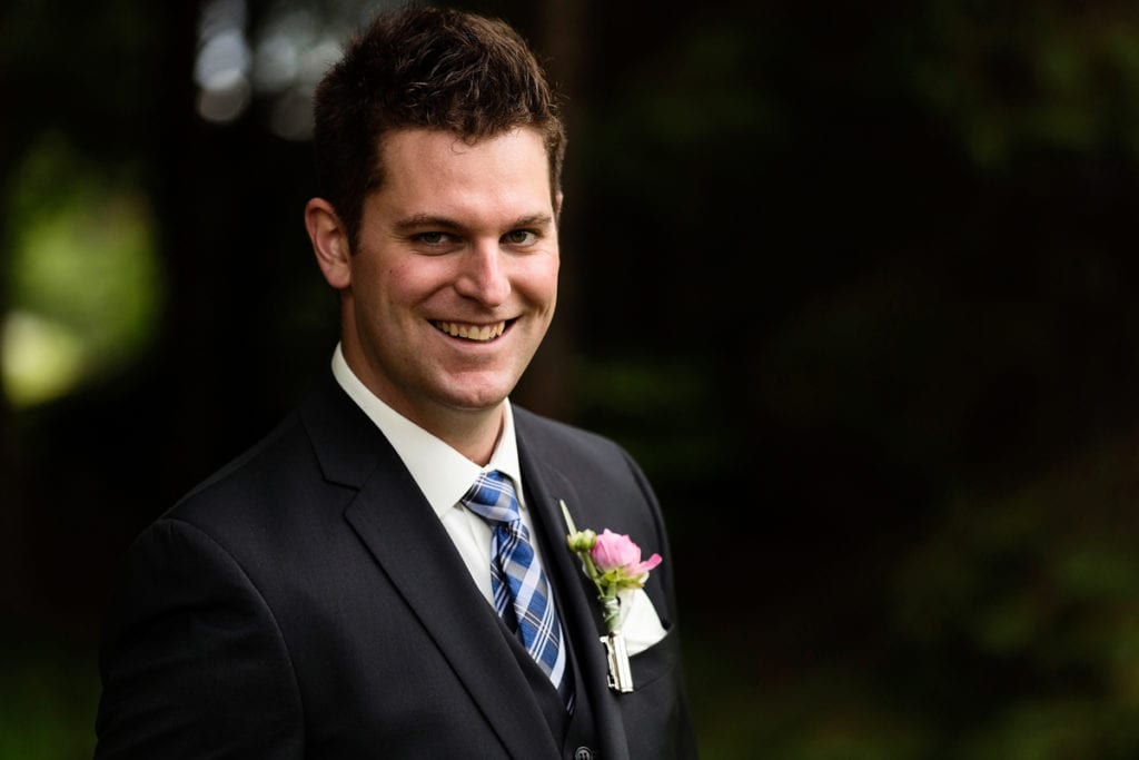 Groom in blue plaid tie with boutonniere