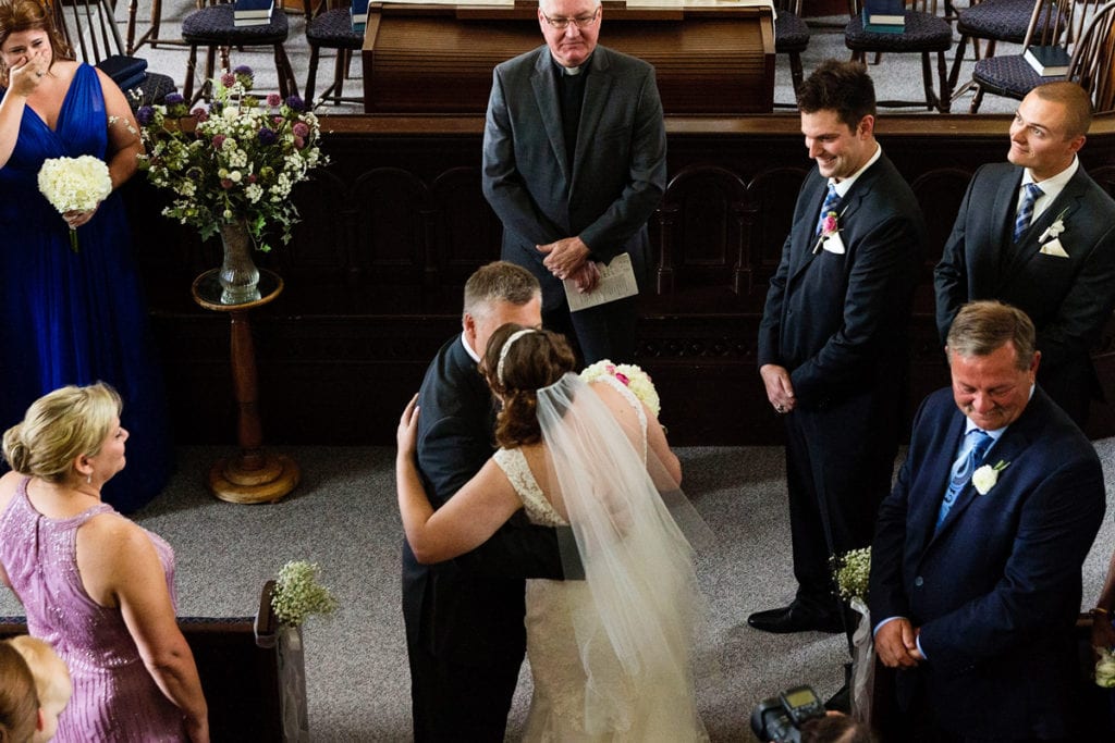 Father of the bride giving away daughter at the altar