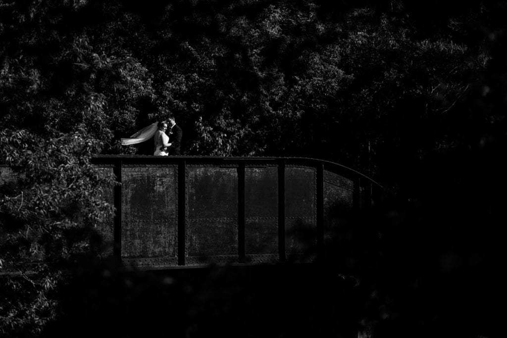 Dramatic photography of bride and groom on country bridge