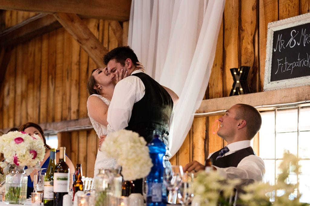 Bride licking groom's face at head table in Williamstown Fairgrounds wedding