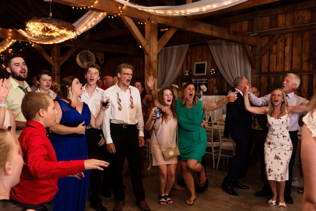 Reception party guests singing on dance floor