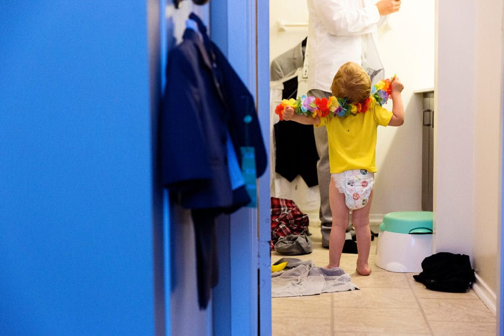 Ring bearer in bathroom trying to help groom prep for wedding