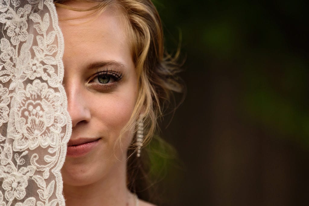 Interesting photo of bride with lace veil partially covering her face