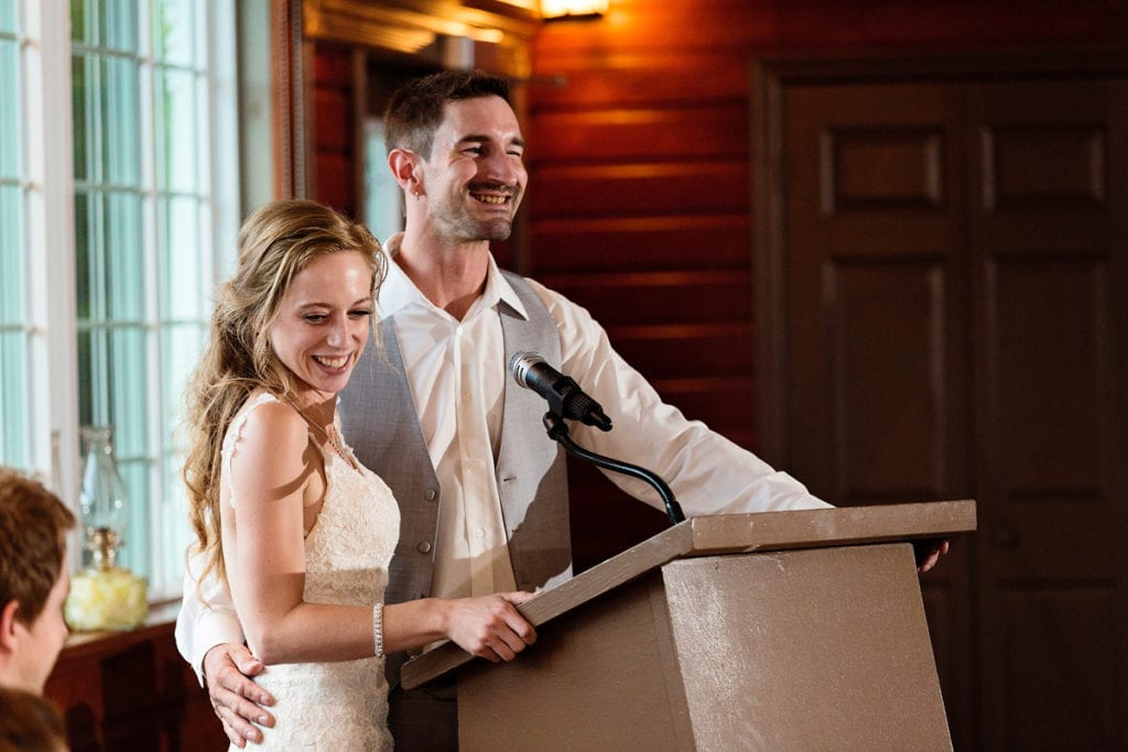 Newlyweds standing at podium for wedding speech