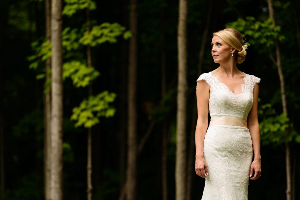 stunning bride in all lace gown against forested background