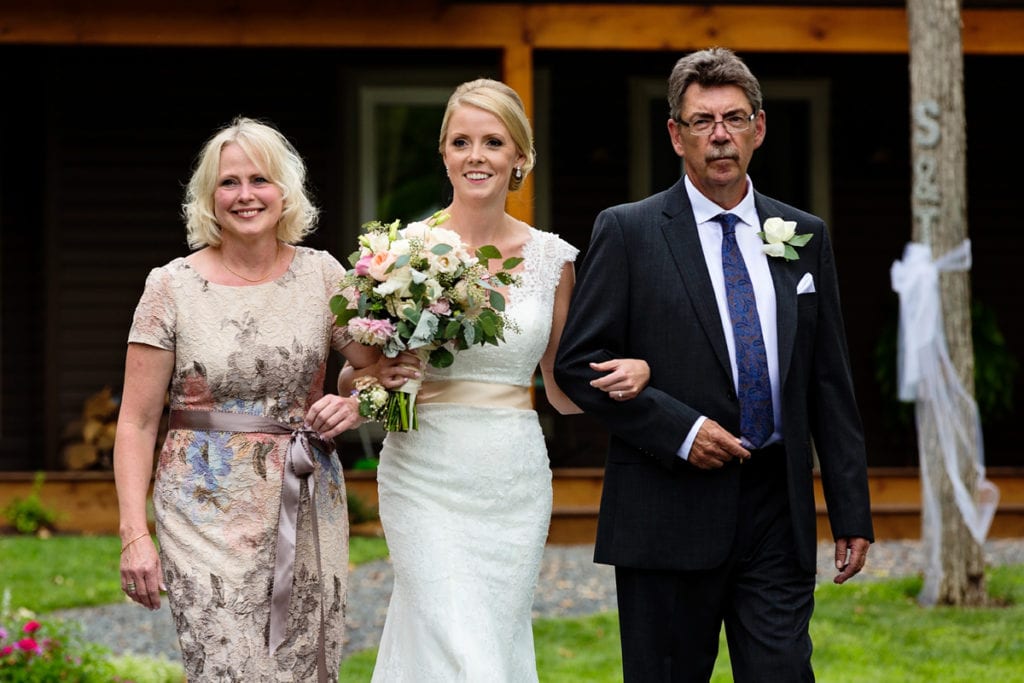 Bride being walked down the aisle by both parents