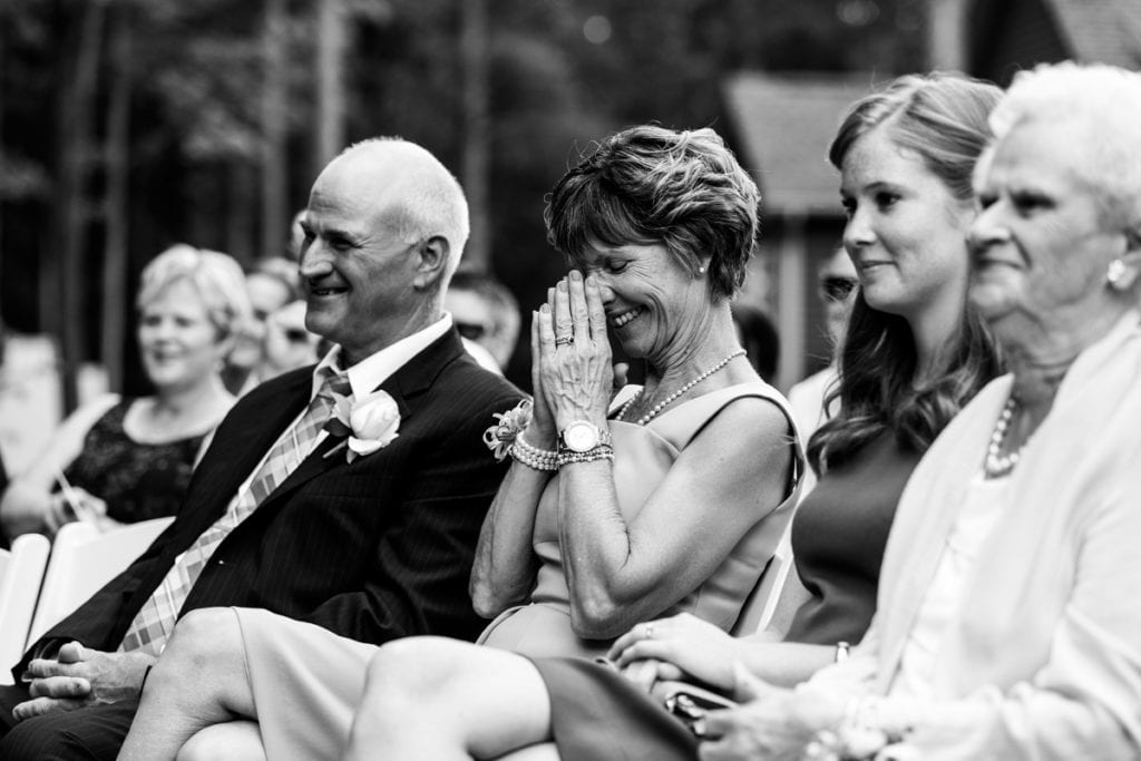 Groom's parents smiling during rural backyard wedding ceremony