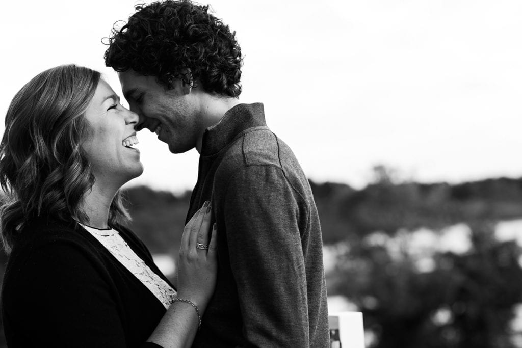 Woman laughing with hand on fiance's chest