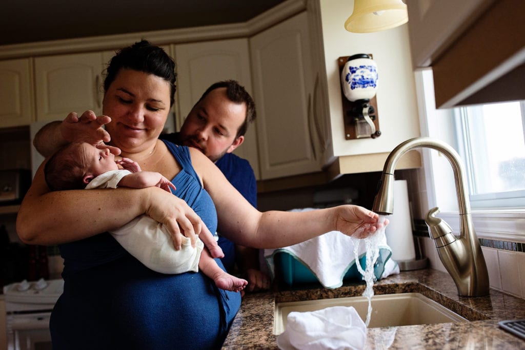 Mom and dad giving newborn son his first bath
