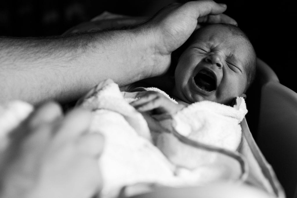 Dad soothing crying newborn