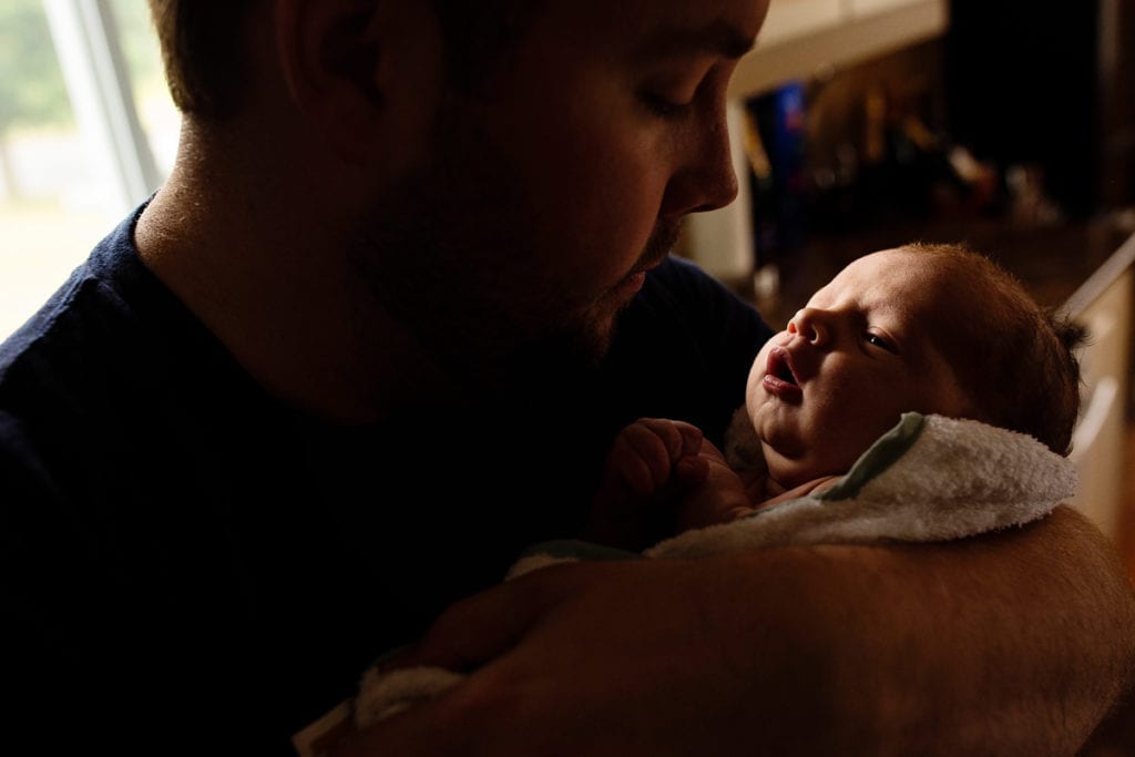Tender moment with dad and newborn baby boy