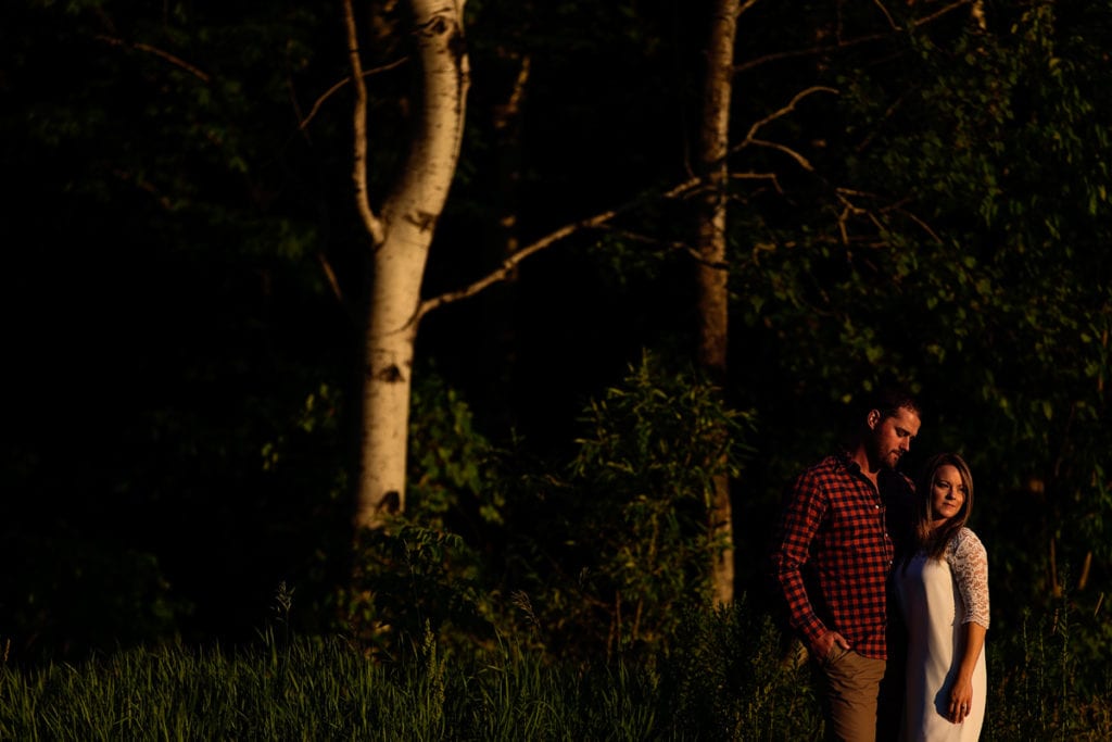 Man in plaid shirt and woman in white dress rural Cornwall engagement shoot