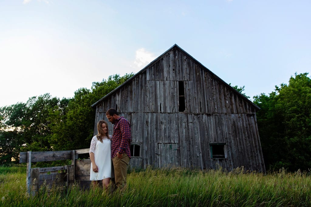 Rural Ontario engagement session in tall grass with barn
