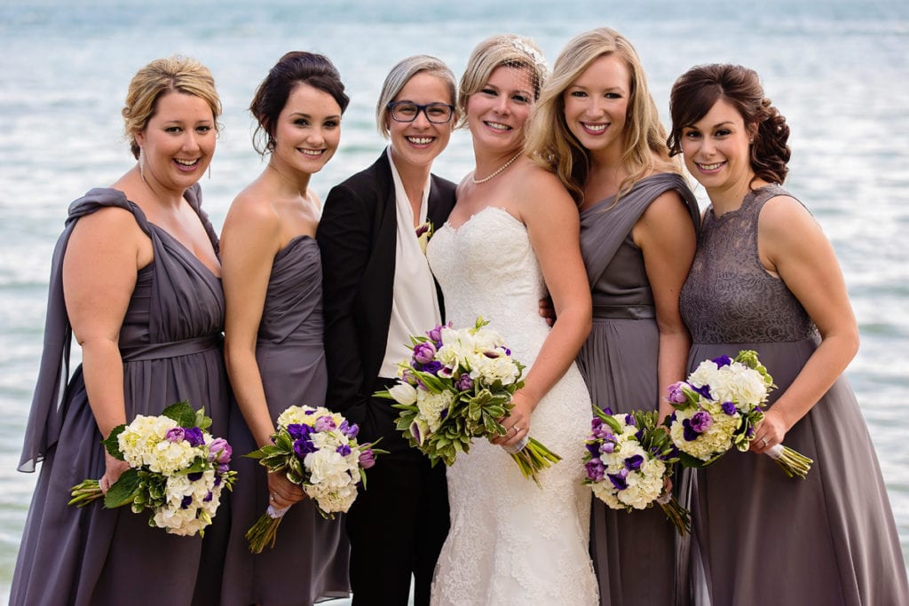 brides with bridesmaids in grey taupe dresses on waterfront dock