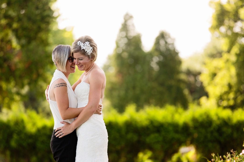 bride with edgy hair holding bride in lace dress in chic cornwall wedding