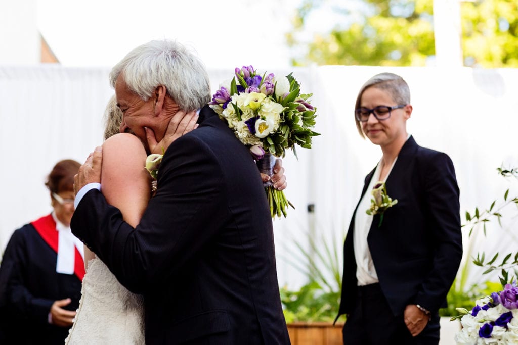 bride and father hugging at alter during wedding ceremony in chic cornwall wedding