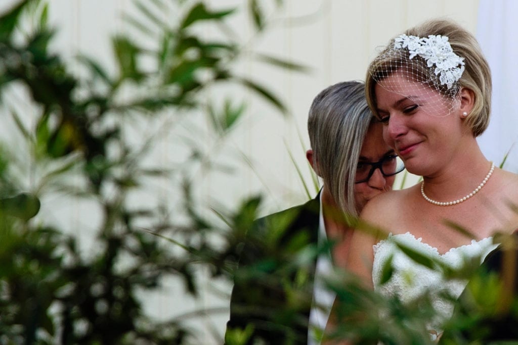 bride kissing bride's shoulder in chic LGBTQ Cornwall wedding