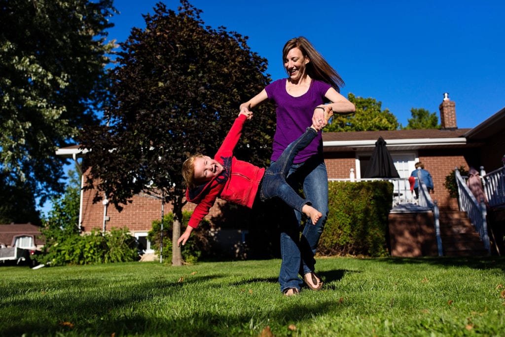 mom twirling little boy by feet and hands