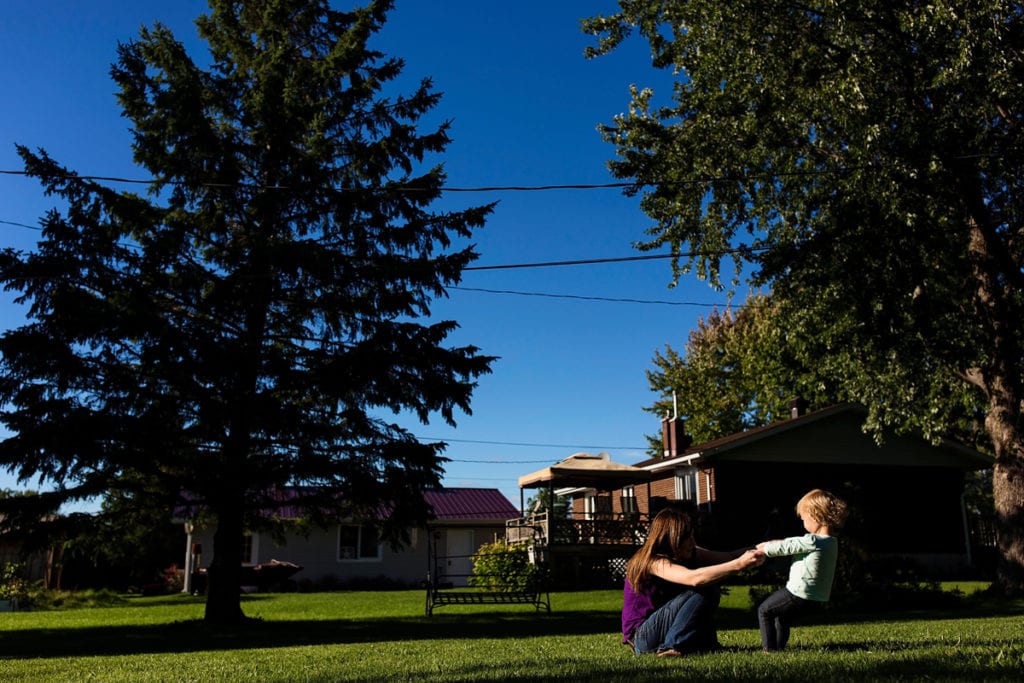 mother and daughter playing in sunny backyard family shoot